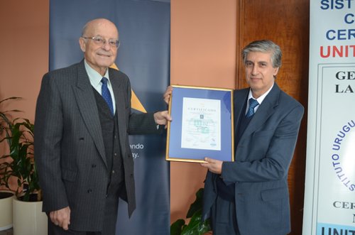 El Cr. Rodolfo Peluffo, Jefe de Tesoerr&iacute;a de ANCAP, recibe el certificado de manos del Presidente de UNIT, Ing. Blas Melissari.
