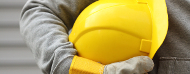 Trabajador con un casco amarillo en sus manos